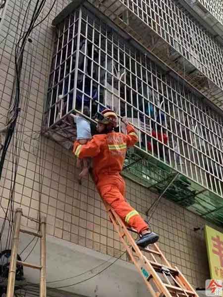柳州基隆：众人架梯托举 消防破门救人